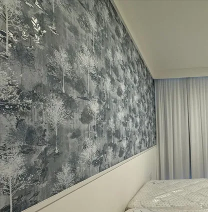 Parede de quarto revestida com papel de parede estampado de árvores em tons de cinza