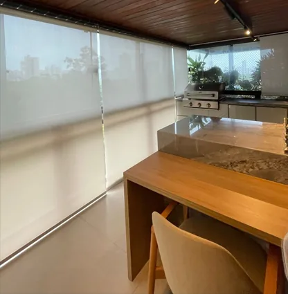 Varanda gourmet com cortinas rolô translúcidas nas janelas